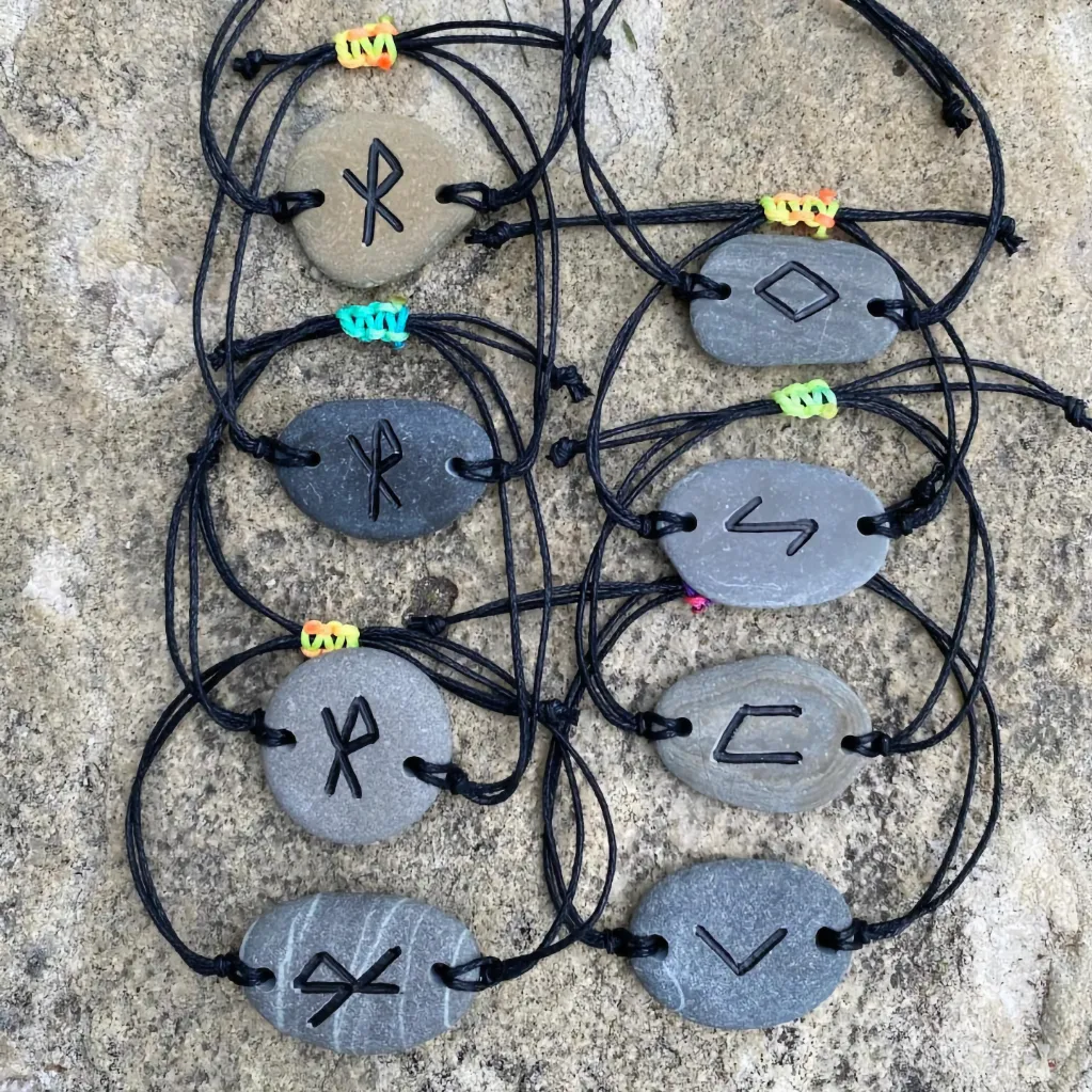 Assortment of Pocket Pebble bracelets with Greek symbols painted on them
